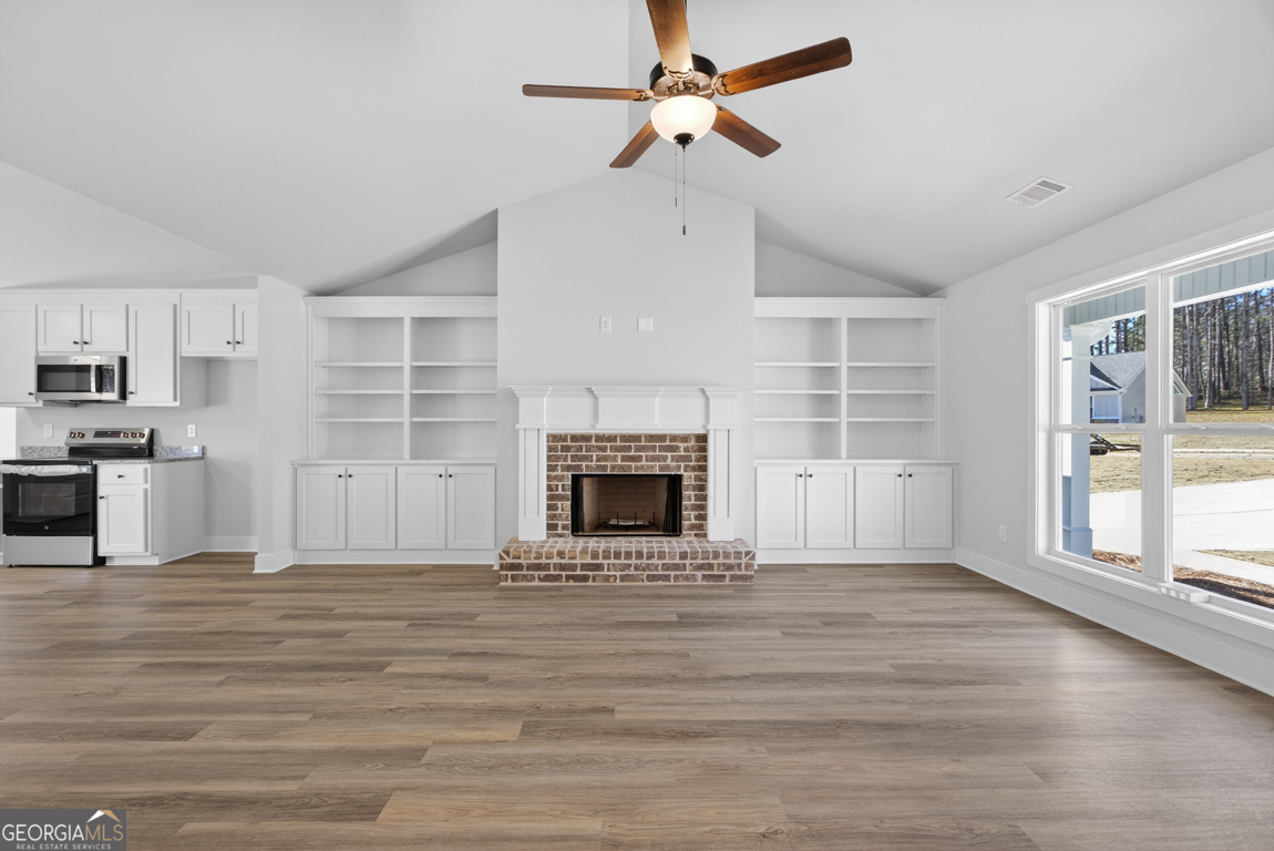 198 Mockingbird Lane, Unit 30 Winder, GA 30680 - Photo 4 of 39 a view of a livingroom with a fireplace a ceiling fan and windows