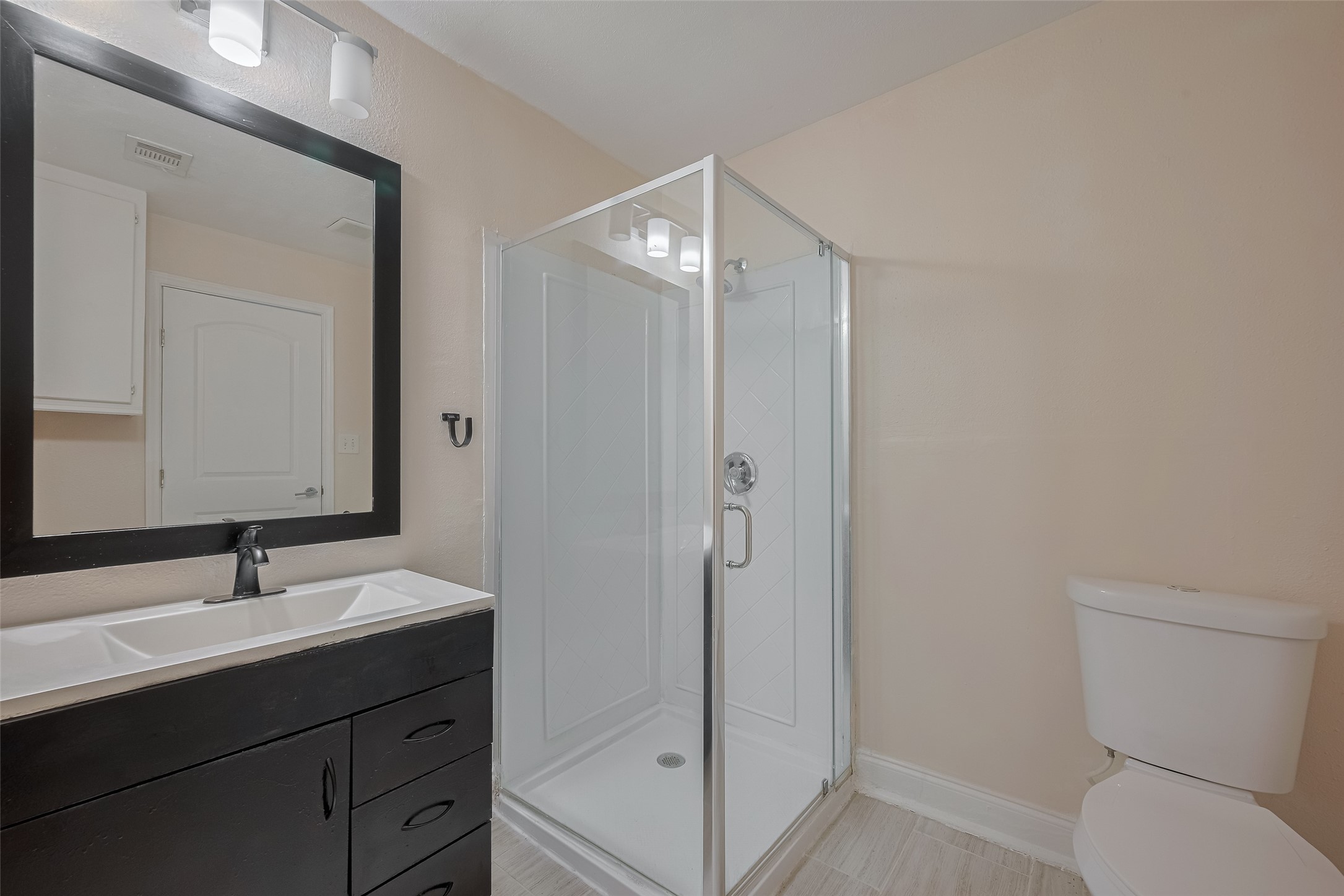 3930 Daphne Street Houston, TX 77021 - Photo 37 of 44 A clean, modern aesthetic continues in the second bathroom, where a single-sink vanity and enclosed shower offer a fresh, practical finish.