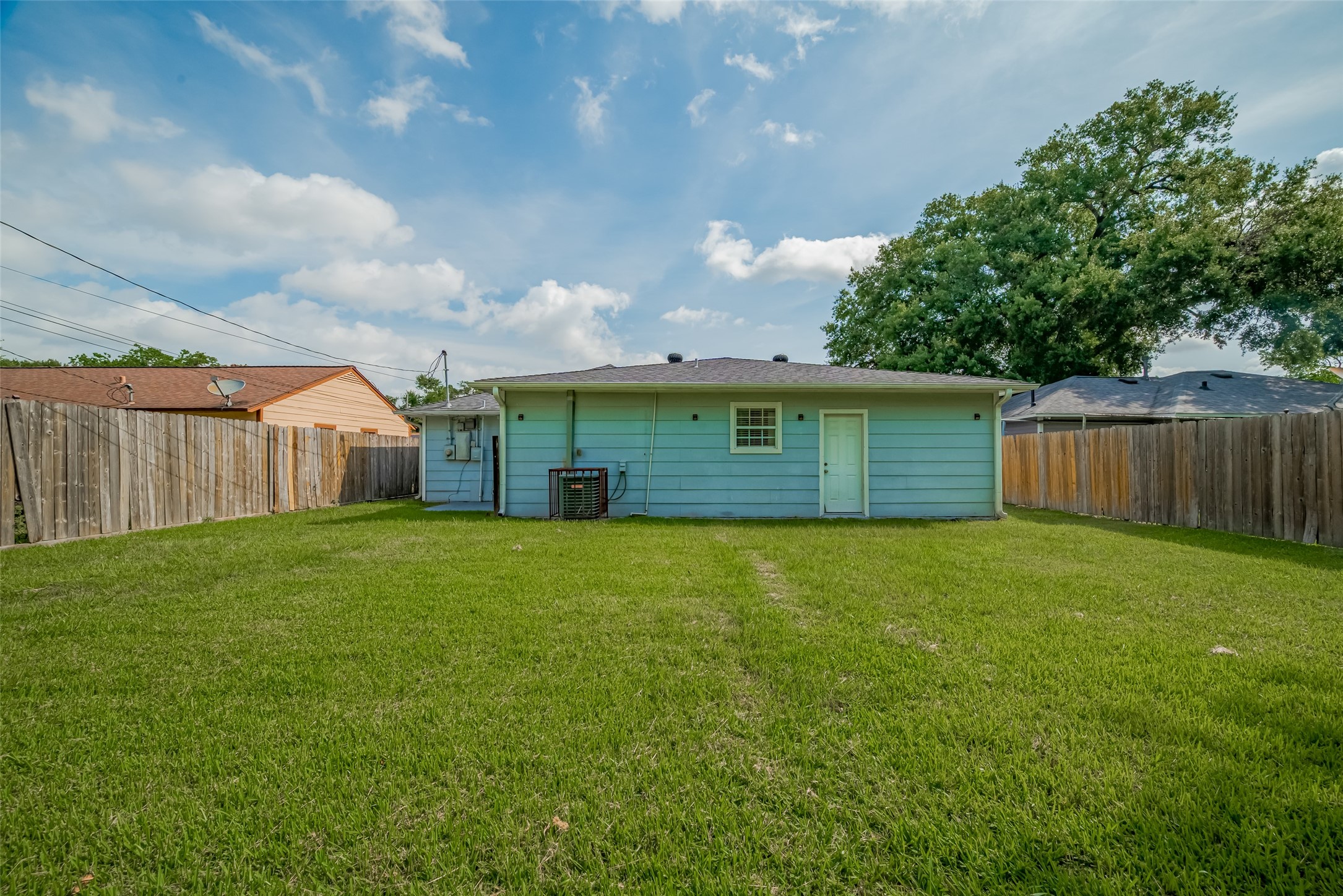 3930 Daphne Street Houston, TX 77021 - Photo 42 of 44 From the back of the property, the home's rear elevation offers a sense of scale and seclusion, where fence lines, lawn, and patio come together in a rare blend of city convenience and personal retreat.