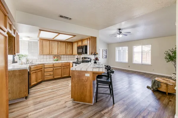 a kitchen with a sink appliances and wooden cabinets