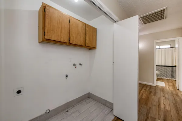 a view of a room with wooden floor and cabinet
