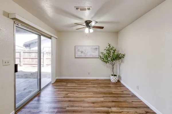a view of a room with wooden floor and a ceiling fan