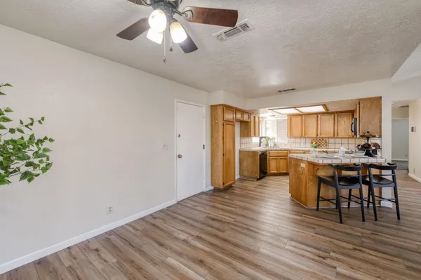 a open kitchen with white cabinets and stainless steel appliances