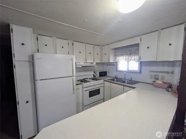 a kitchen with sink and mirror
