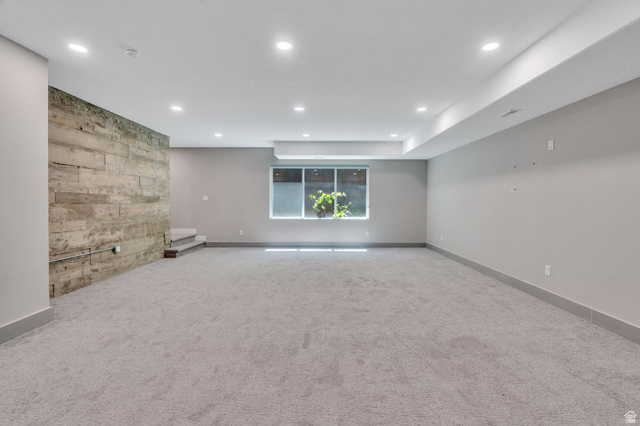 7045 South 300 East Midvale, UT 84047 - Photo 31 of 49 Spacious room featuring light gray carpeting, recessed lighting, a modern window, and a distinctive wood-textured accent wall