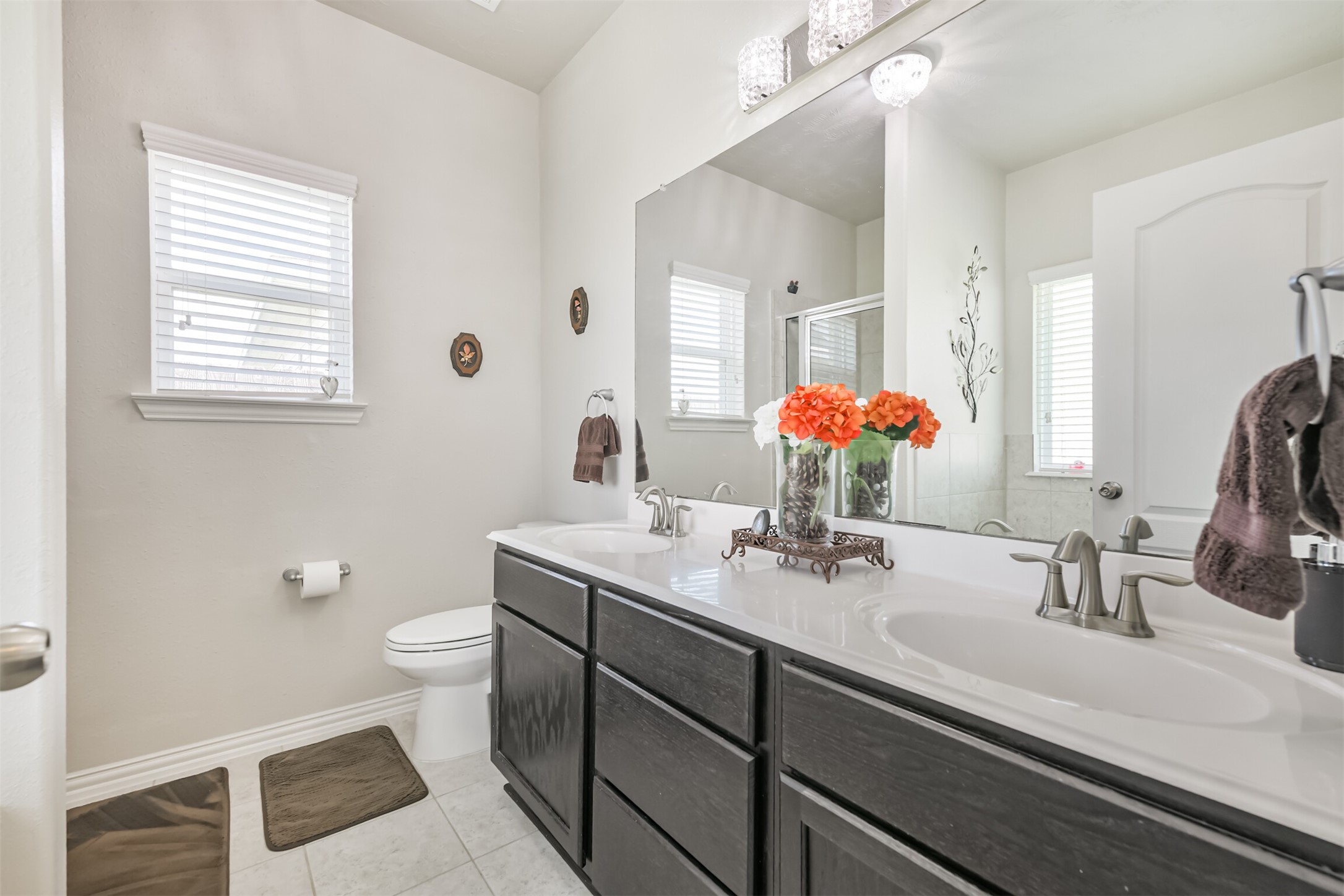 7527 Windsor Valley Lane Houston, TX 77049 - Photo 24 of 35 a bathroom with a granite countertop sink a large mirror a toilet and a window
