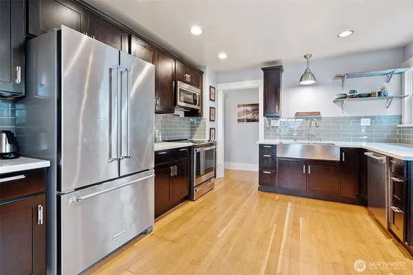 a kitchen with stainless steel appliances granite countertop a refrigerator a stove and a sink
