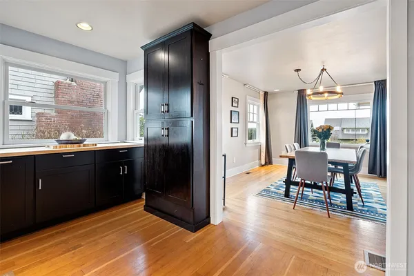a kitchen with stainless steel appliances wooden floor and dining table