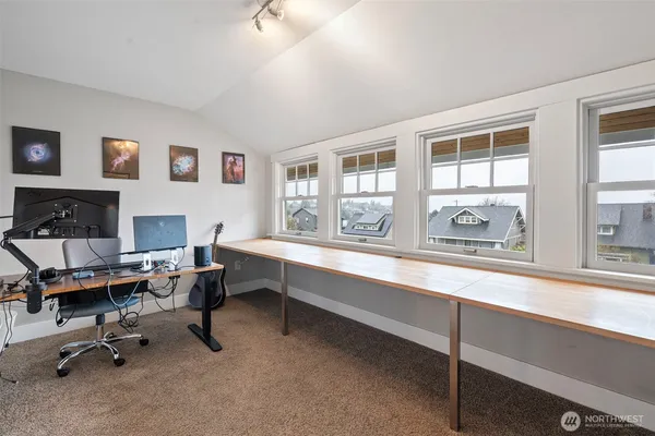 a view of a workspace with furniture and a window