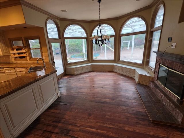 a view of a kitchen with kitchen island a sink wooden floor and a living room view