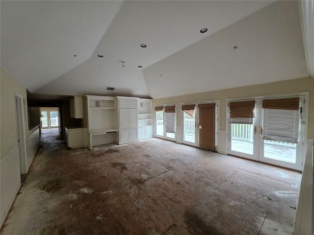 an empty room with wooden floor and a refrigerator