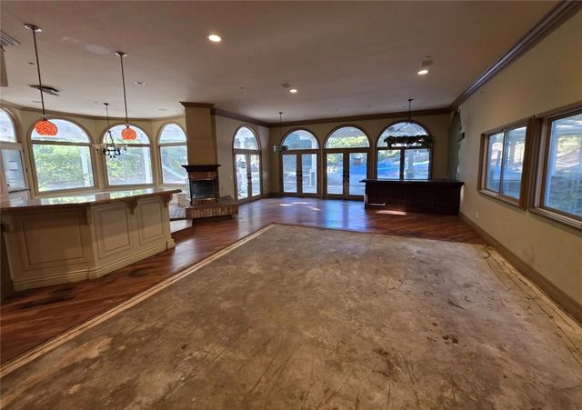 a view of open kitchen with stainless steel appliances granite countertop a stove and a large window