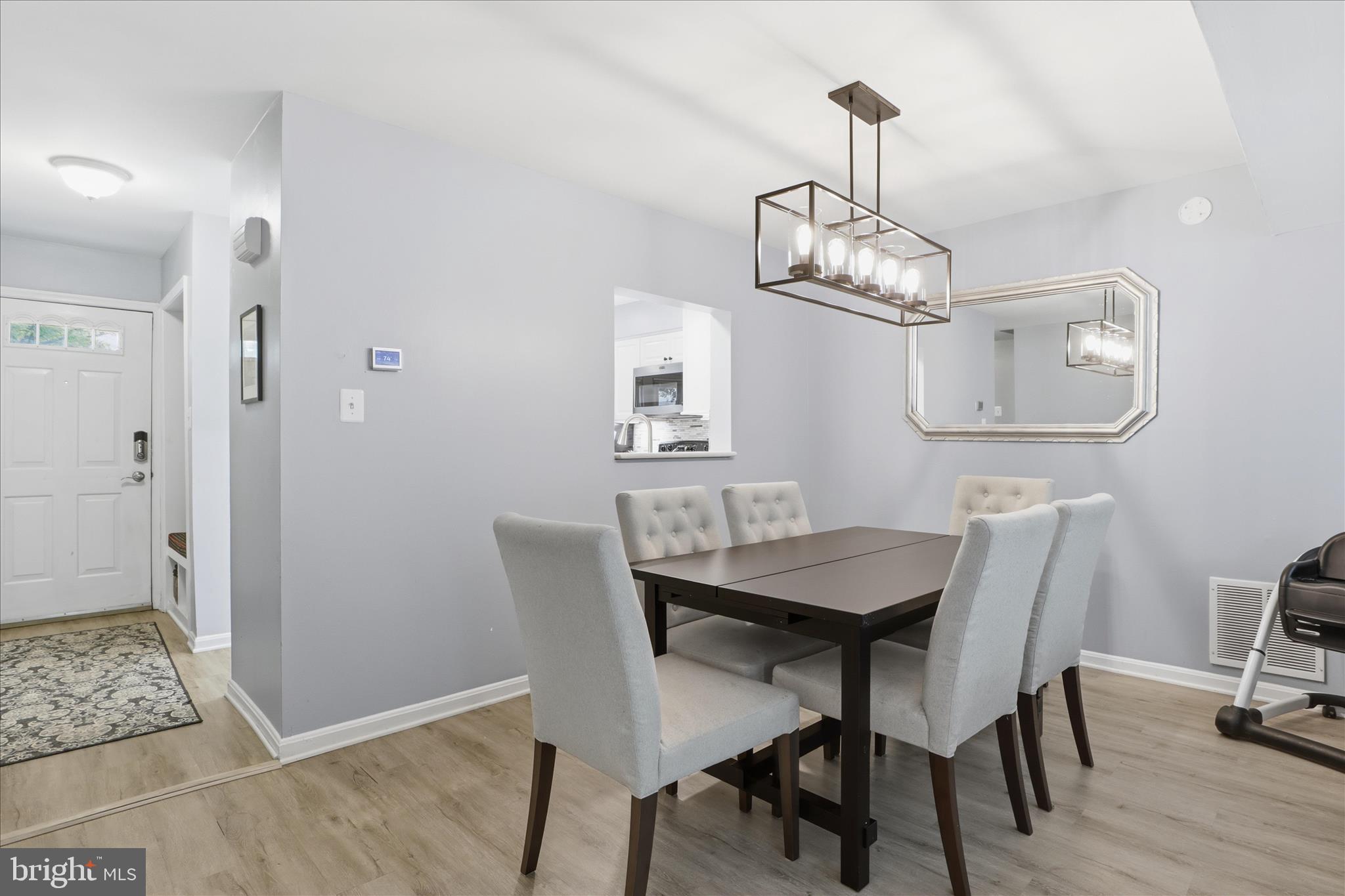 71 Kinsman View Circle Silver Spring, MD 20901 - Photo 5 of 42 a view of a dining room with wooden floor a chandelier a wooden table and chairs