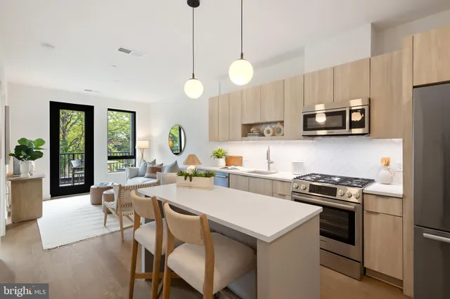 a kitchen with a stove a microwave a dining table and chairs with wooden floor