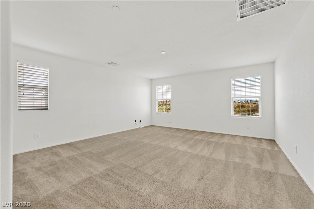 155 Fulgora Street Henderson, NV 89074 - Photo 9 of 30 A generously proportioned room with neutral carpeting and ample natural illumination.