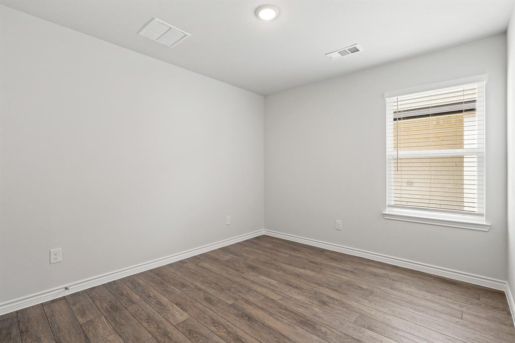 1603 Romans Road Ennis, TX 75119 - Photo 16 of 21 wooden floor in an empty room with a window