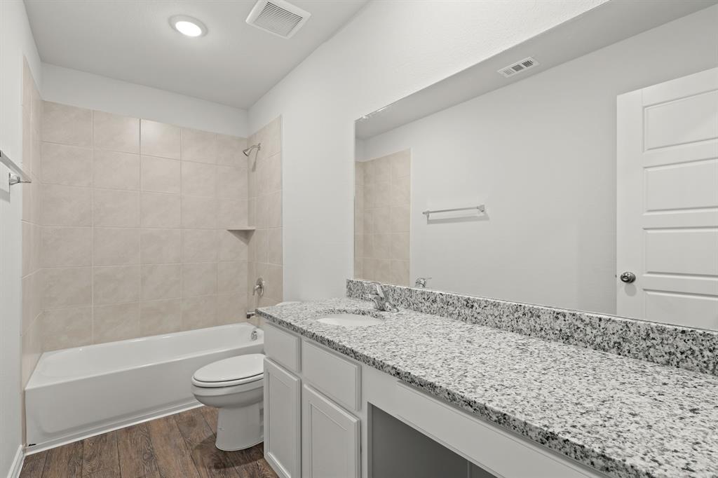1603 Romans Road Ennis, TX 75119 - Photo 17 of 21 a bathroom with a granite countertop sink toilet and shower