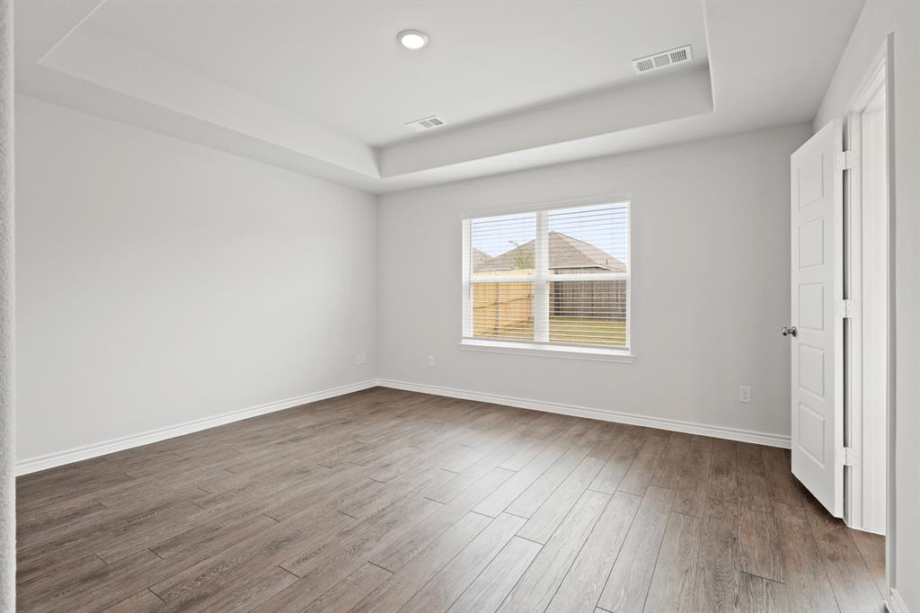 1603 Romans Road Ennis, TX 75119 - Photo 10 of 21 an empty room with wooden floor and windows