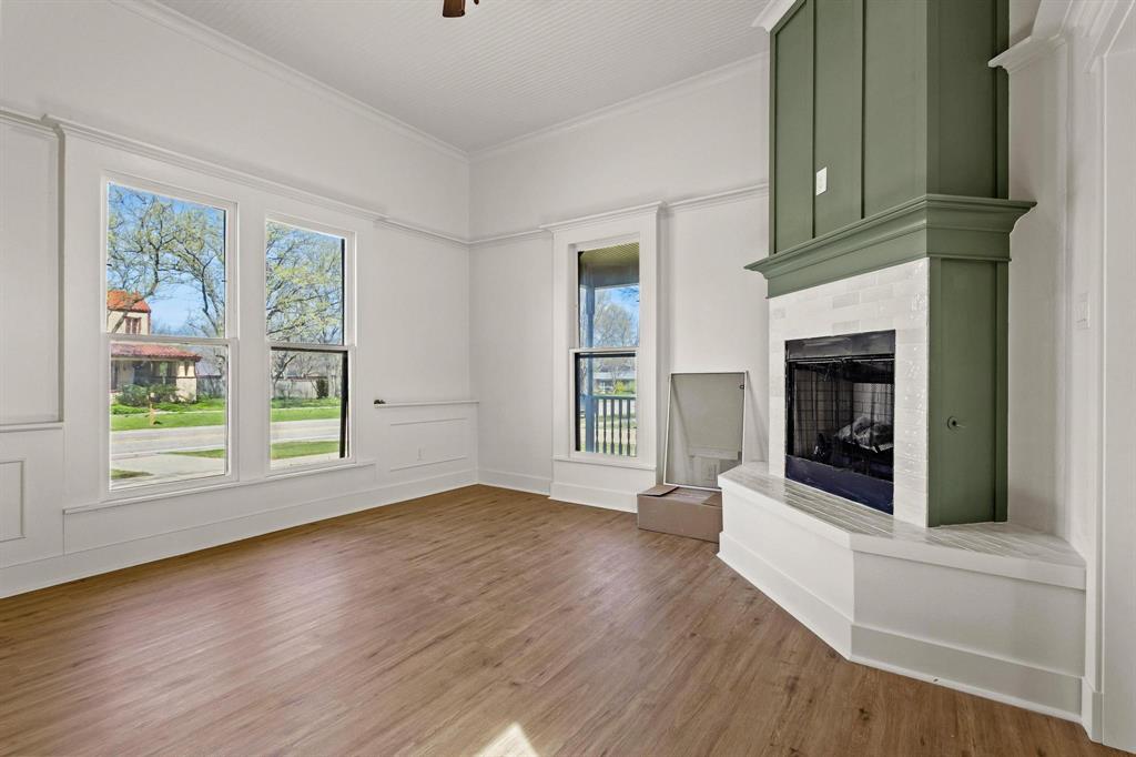 331 West Grand Street Whitewright, TX 75491 - Photo 12 of 39 wooden floor fireplace and windows in an empty room