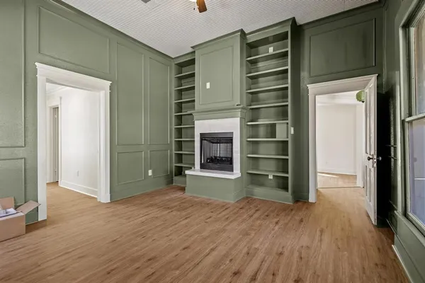 a view of an empty room with a closet and wooden floor