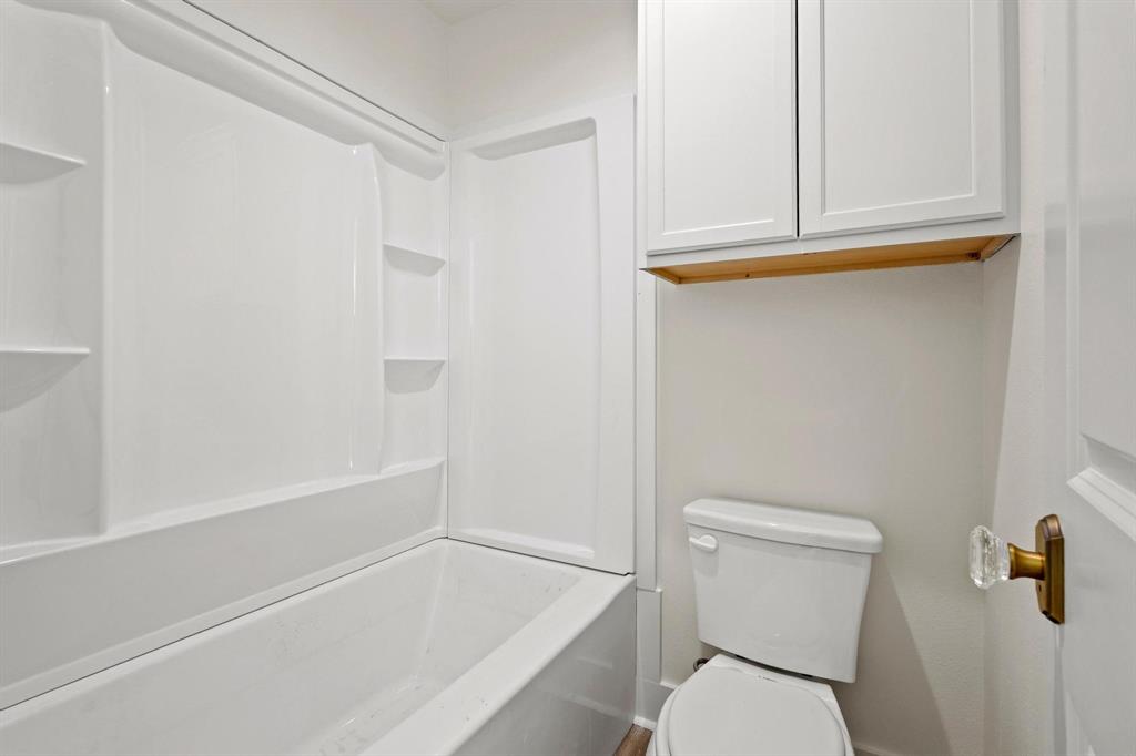 331 West Grand Street Whitewright, TX 75491 - Photo 31 of 39 a bathroom with a toilet and a bathtub