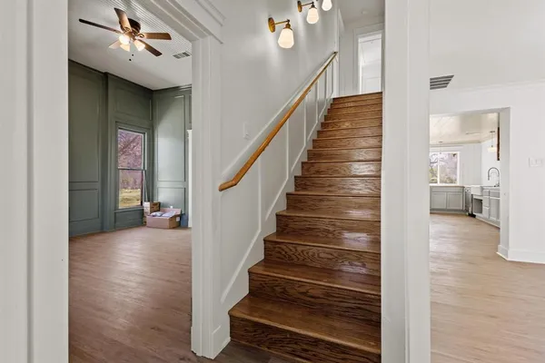 a view of a hallway with wooden floor and entryway