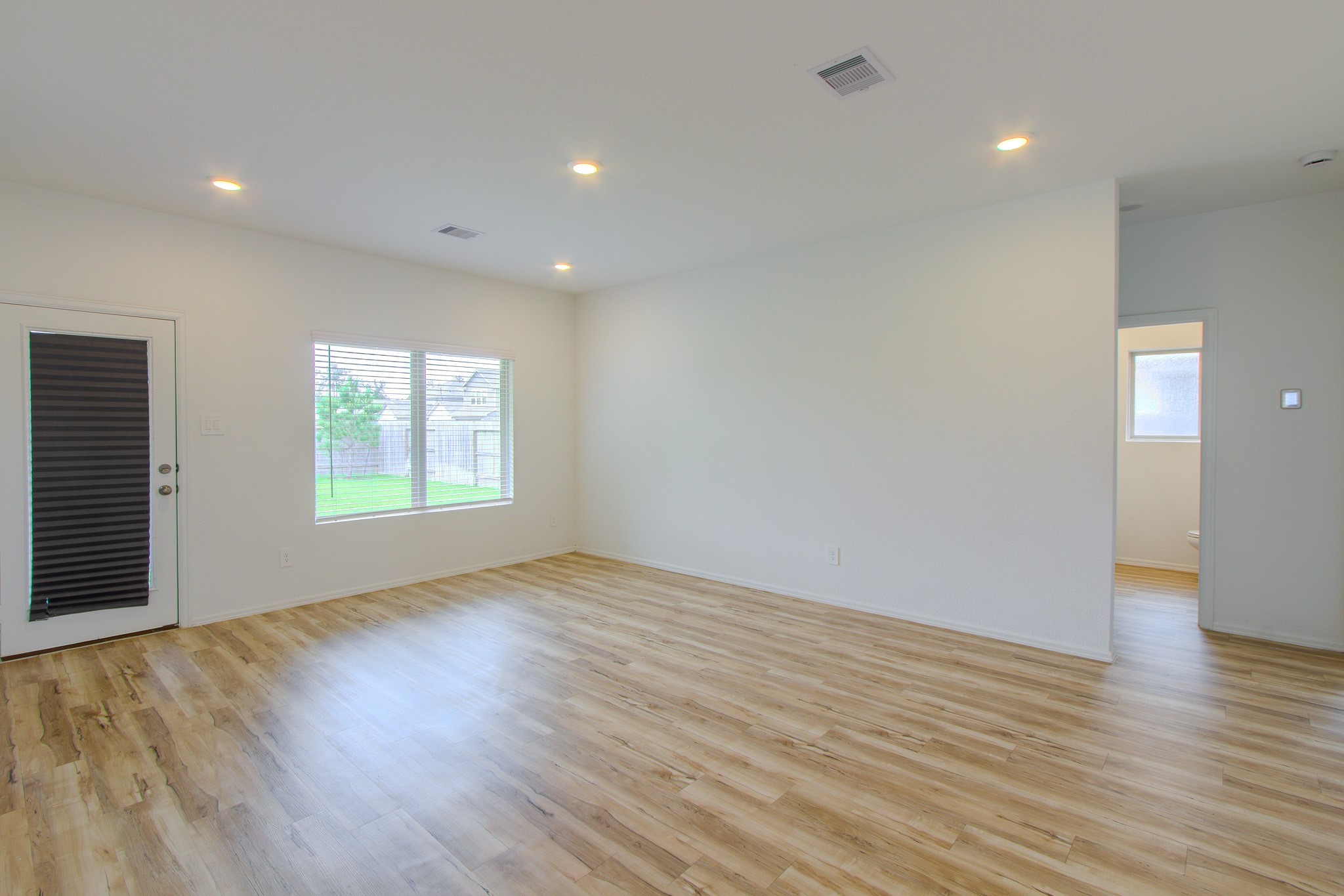 3113 Catalonion Court Conroe, TX 77301 - Photo 16 of 45 an empty room with wooden floor and windows