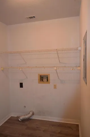 a view of an empty room with wooden floor and windows