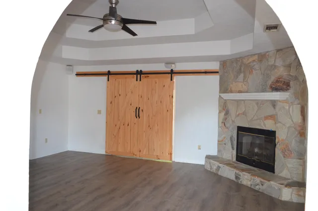 a view of empty room with wooden floor and fireplace