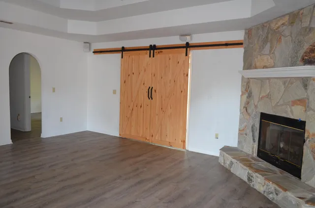 a view of kitchen with granite countertop stainless steel appliances a sink and wooden floor