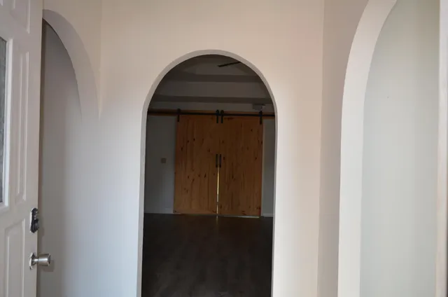 an empty room with wooden floor and closet area