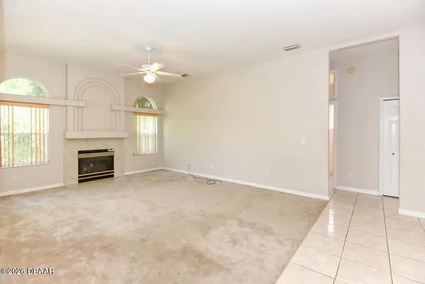 an empty room with windows and fireplace