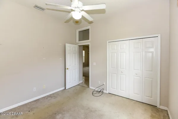an empty room with a ceiling fan and a window