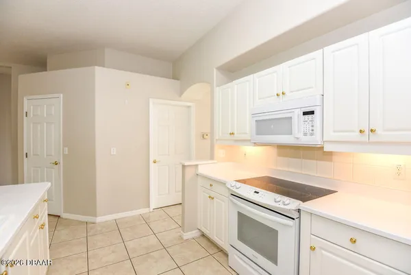 a kitchen with white cabinets and white appliances