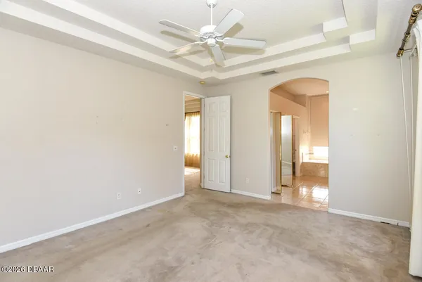 an empty room with a ceiling fan and a window