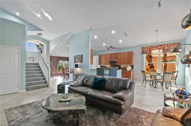 a living room with furniture kitchen view and a wooden floor