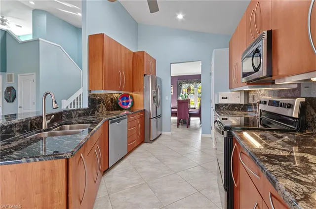 a kitchen with stainless steel appliances granite countertop a stove a sink and a microwave
