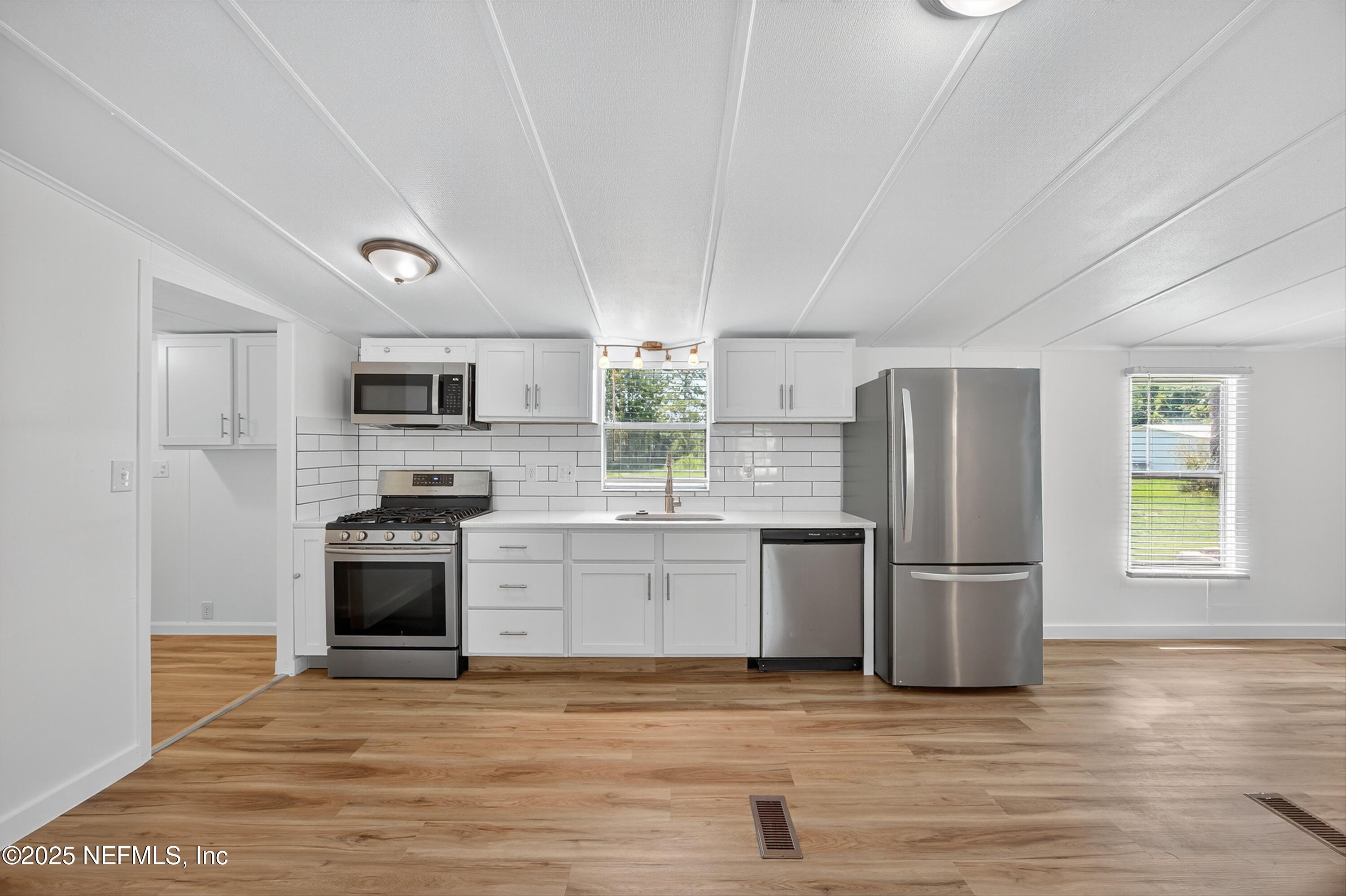 349 Stokes Landing Road St. Augustine, FL 32095 - Photo 16 of 45 a kitchen with stainless steel appliances a refrigerator sink and stove