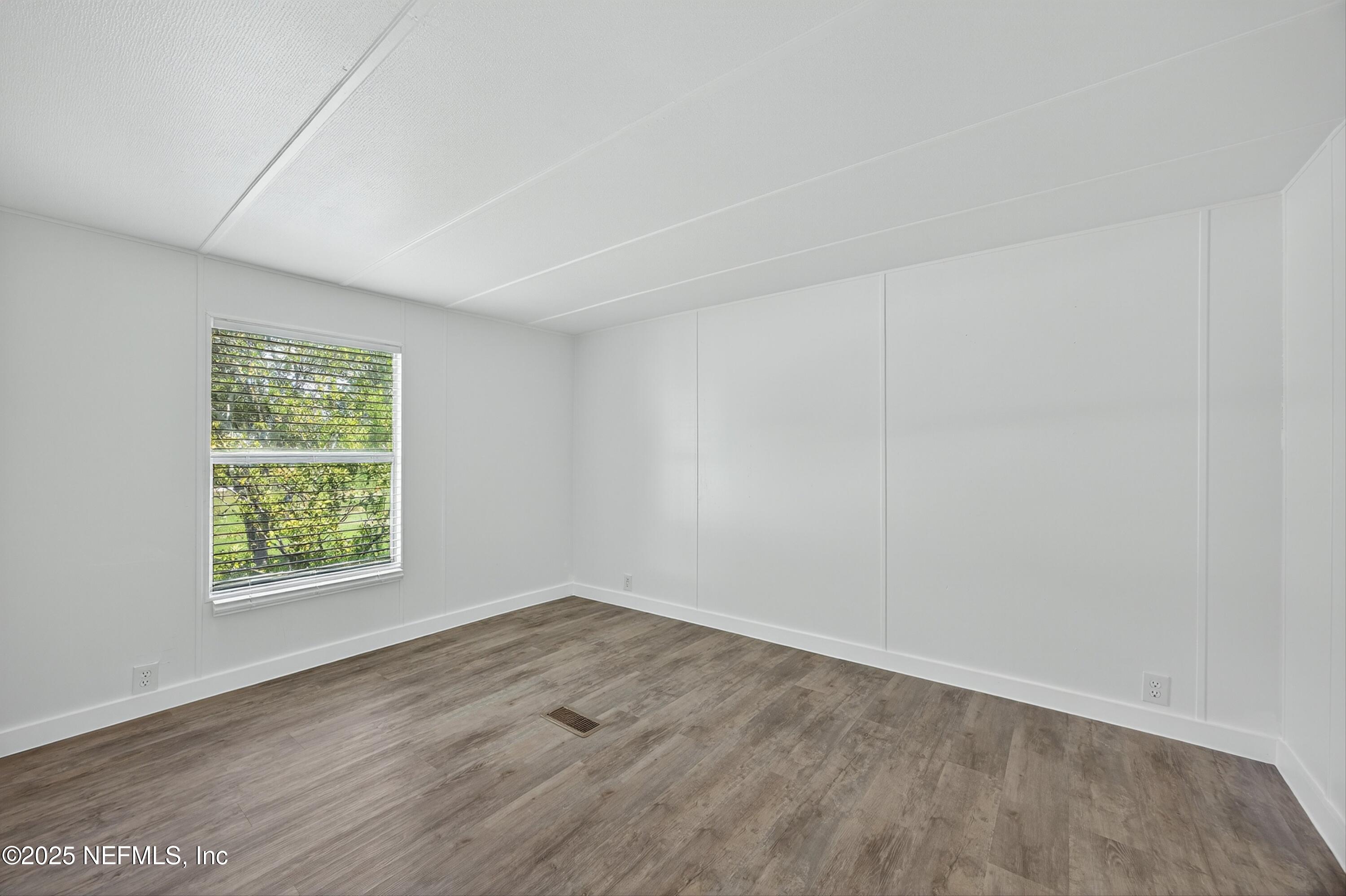 349 Stokes Landing Road St. Augustine, FL 32095 - Photo 26 of 45 an empty room with wooden floor and windows