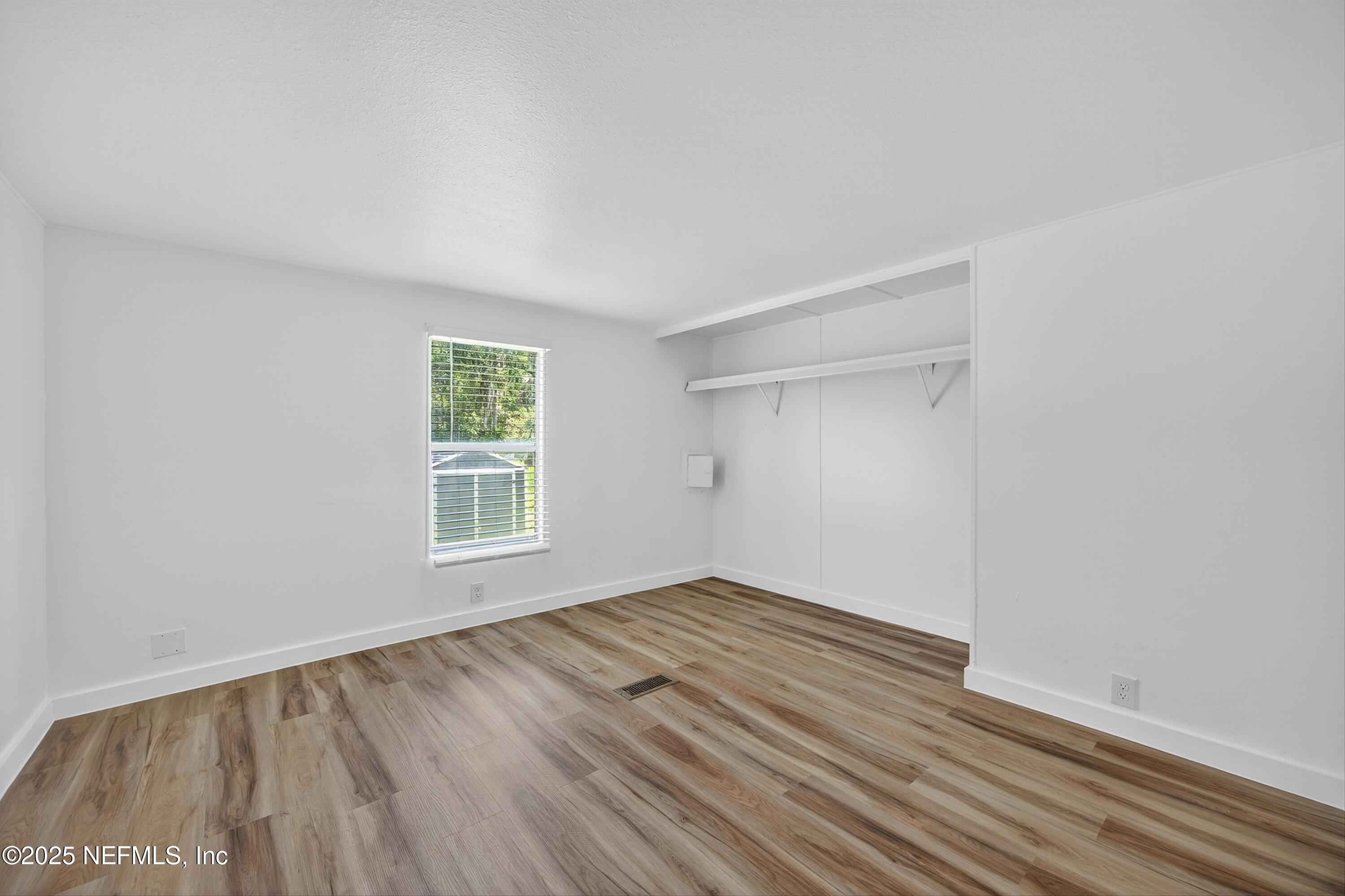 349 Stokes Landing Road St. Augustine, FL 32095 - Photo 31 of 45 a view of an empty room with wooden floor and a window