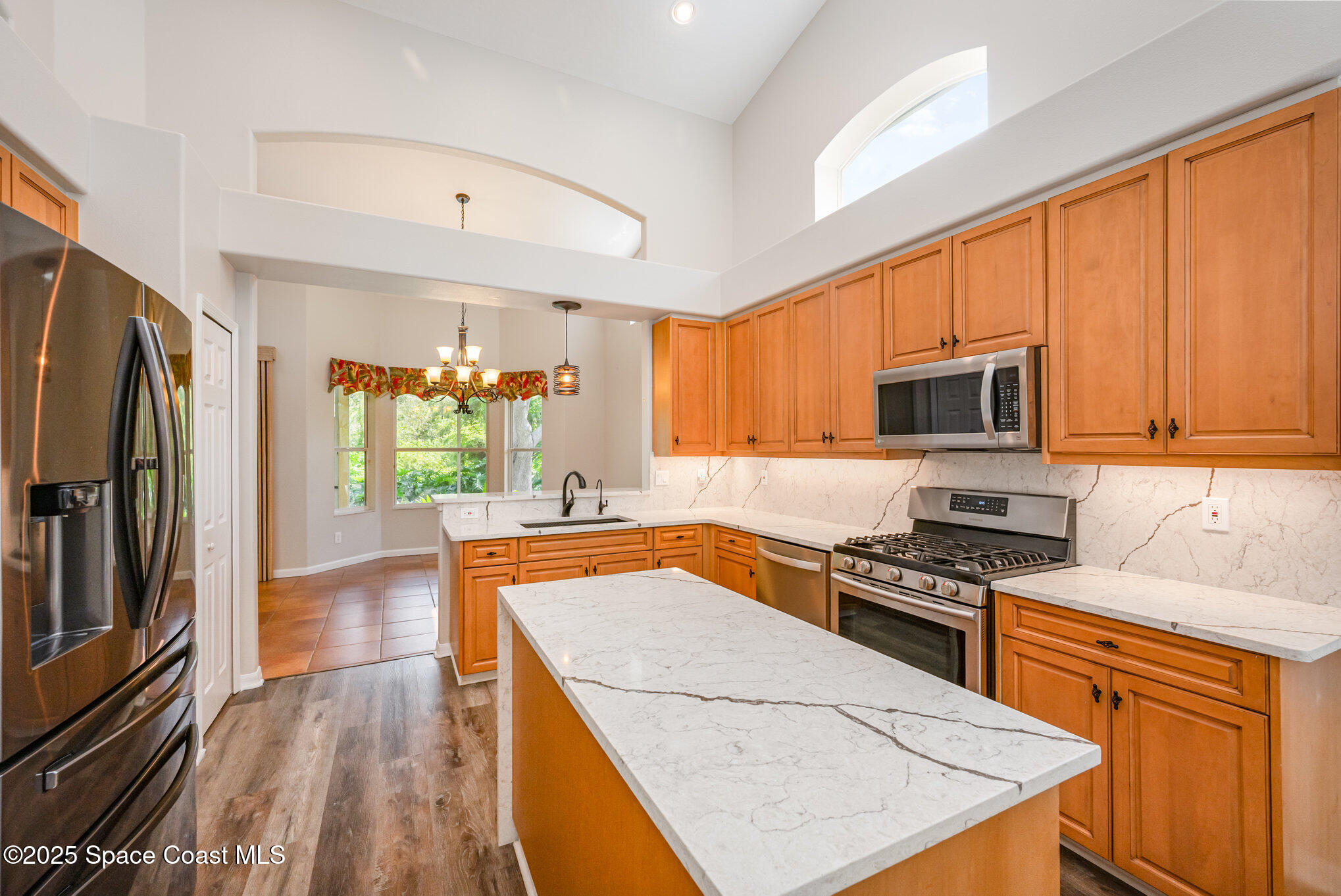 968 Wimbledon Drive Melbourne, FL 32940 - Photo 13 of 47 a kitchen with stainless steel appliances granite countertop wooden cabinets a stove top oven a sink and dishwasher a refrigerator with wooden floor
