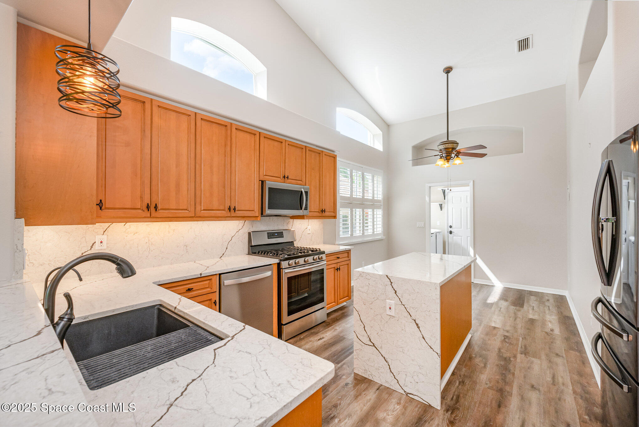 968 Wimbledon Drive Melbourne, FL 32940 - Photo 14 of 47 a kitchen with stainless steel appliances granite countertop a sink a stove and a wooden floors