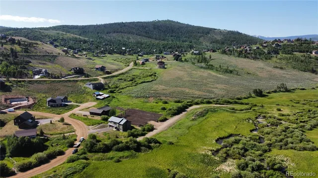 a view of a lush green hillside and houses