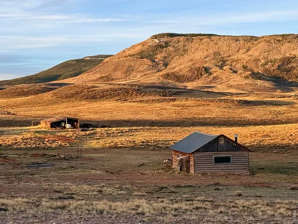 a view of a large mountain with wooden fence