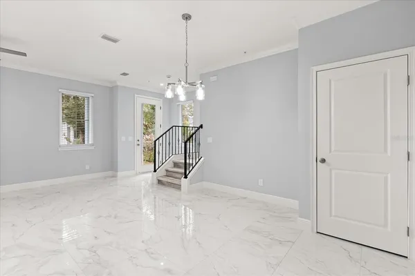 a view of a livingroom with a chandelier fan and windows