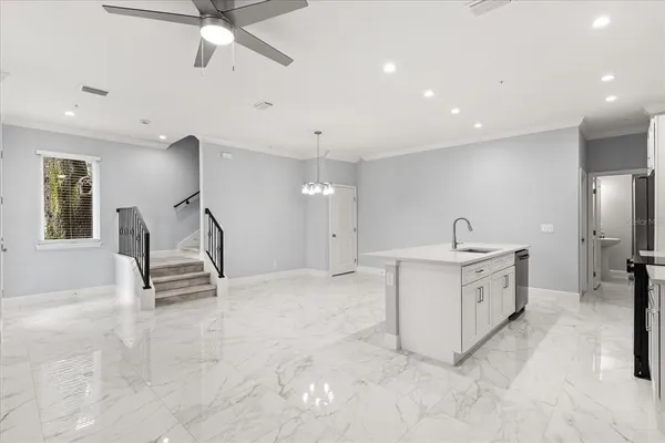 a view of a kitchen with sink electronic appliances and furniture