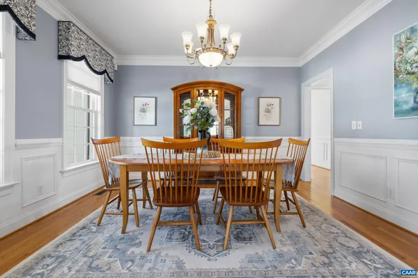 a kitchen with stainless steel appliances granite countertop a table chairs refrigerator and sink