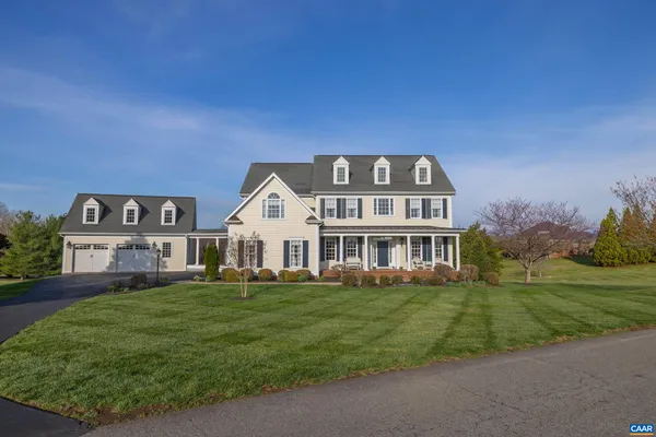 a view of a house with a big yard and large trees