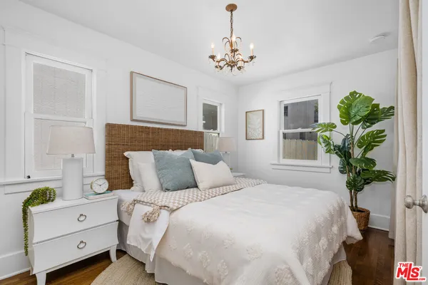 a bedroom with a bed and a potted plant