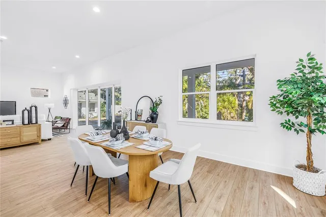 a dining room with furniture potted plants and wooden floor